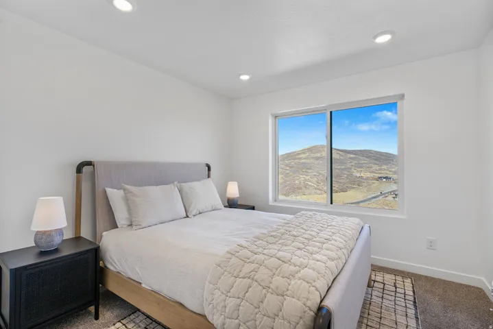 Spacious room featuring a large window with mountain scenery, recessed lighting, and light-toned walls