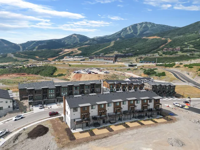 Modern multi-story townhomes with stone and wood-look siding exteriors