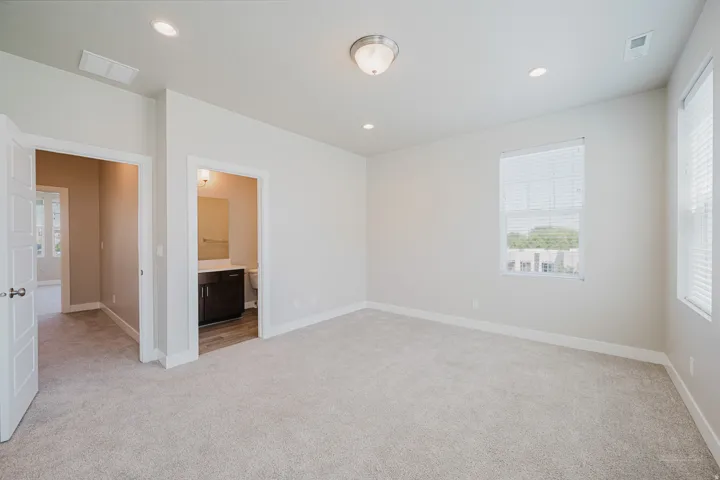 Spacious room featuring neutral carpeting, recessed lighting, and a ceiling-mounted fixture