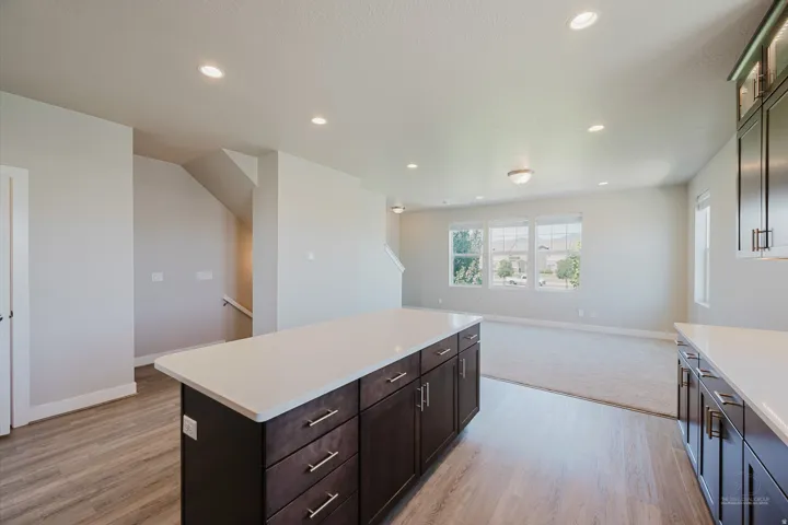 Kitchen island with dark wood-finish cabinetry and light-toned countertop