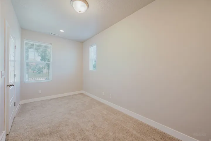 Neutral-toned wall paint throughout, complemented by plush carpet flooring