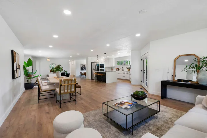 Open-concept living area featuring wood-finish flooring, recessed lighting, and white walls