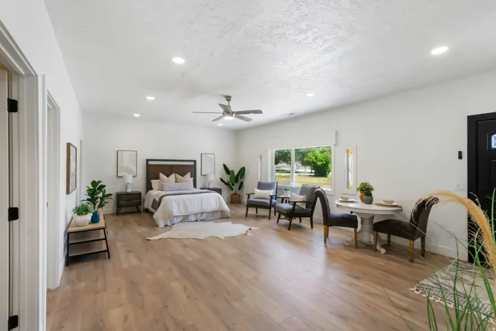 Spacious bedroom featuring light wood-finish flooring, recessed lighting, and a ceiling fan