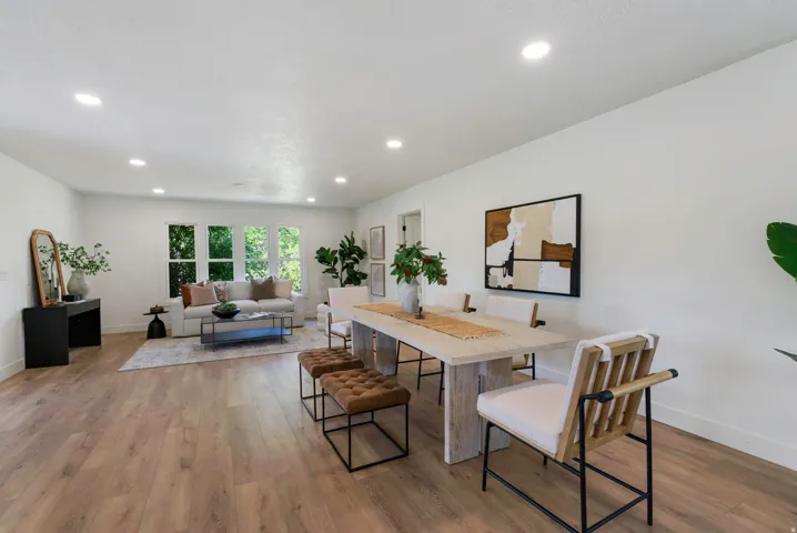Open concept living and dining area featuring wood-finish flooring, recessed lighting, and white walls