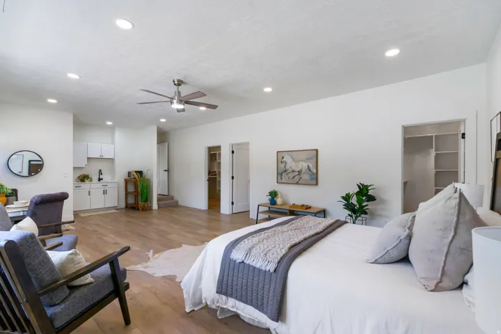 Spacious room featuring wood-finish flooring, recessed lighting, and a ceiling fan