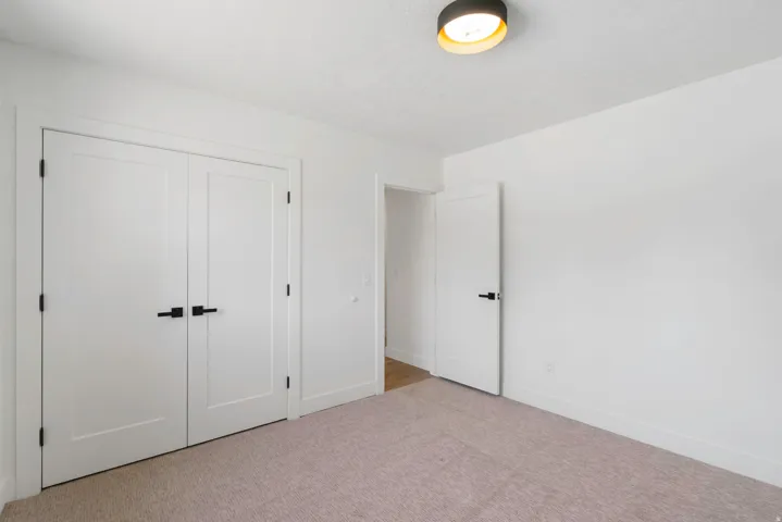 Neutral tone carpeting complemented by white walls and trim