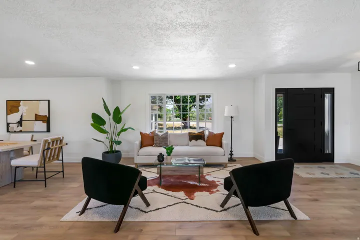 Bright living space featuring wood-finish flooring, a contemporary front entry door with sidelights, recessed lighting, and a multi-pane window