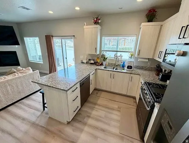 Modern kitchen featuring wood-finish flooring and light-toned cabinetry