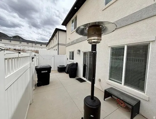 Private concrete patio area with white vinyl fencing