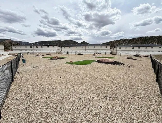 Spacious outdoor area featuring a gravel surface, fenced perimeter, and dedicated artificial turf sections