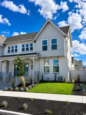 Modern townhome exterior featuring light-colored stucco and board-and-batten siding