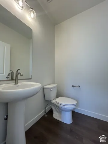 Pedestal sink with brushed nickel faucet, mirror, and track lighting