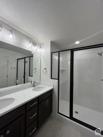 Bathroom featuring a dual vanity with dark wood-finish cabinetry, light-toned countertops, and dual undermount sinks