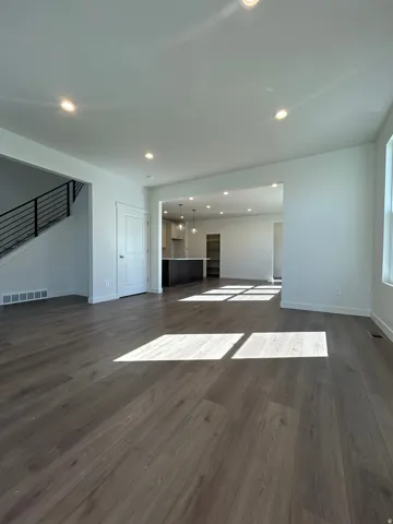 Spacious interior featuring wood-finish flooring, recessed ceiling lighting, and a contemporary open-concept layout