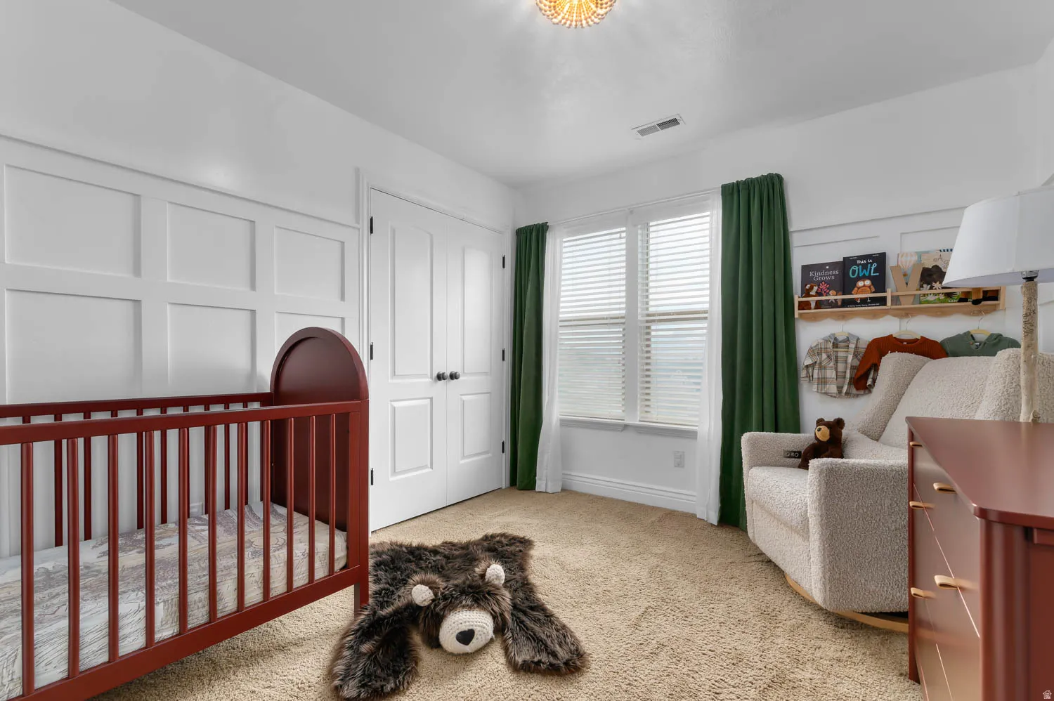 Room featuring wainscoting accent walls, light-colored carpeting, and a double window with blinds