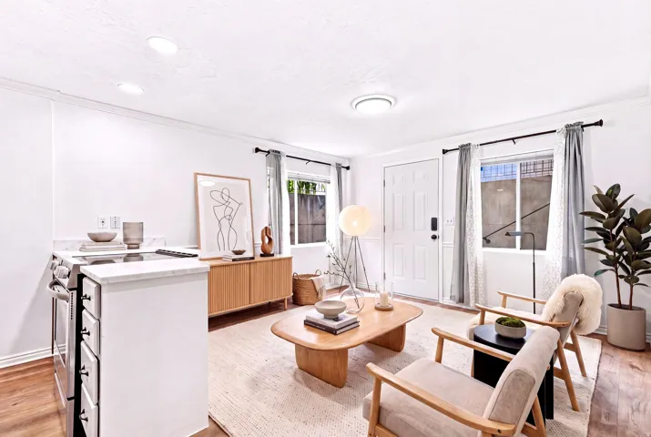 Bright living area featuring white walls and wood-finish flooring