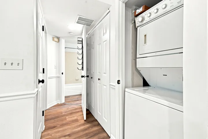 Dedicated laundry closet featuring a white stackable washer and dryer