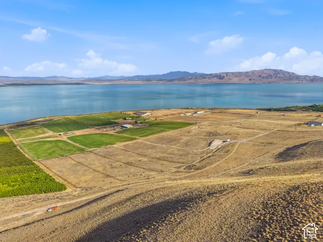 Expansive land parcel featuring open fields and a significant waterfront presence