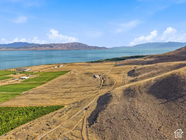 Expansive land parcel featuring natural terrain, partial agricultural cultivation, and waterfront proximity