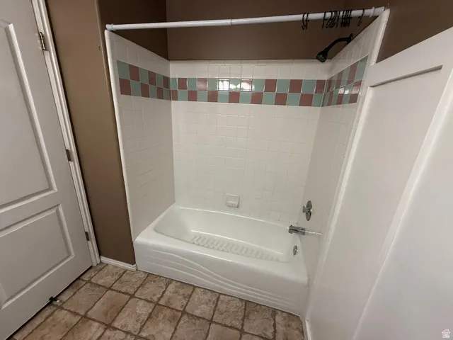 White bathtub and shower combination with chrome fixtures
