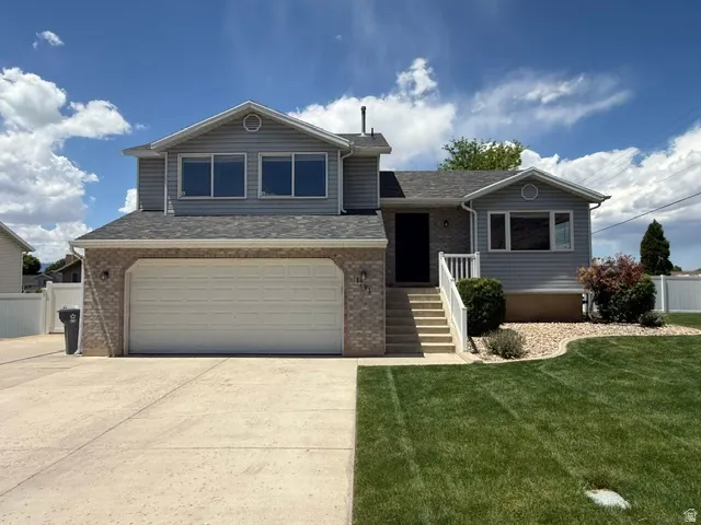 Two-story residence featuring light gray siding and a brick facade