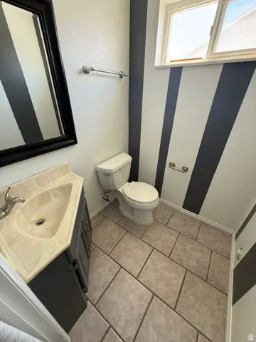 Bathroom featuring a single vanity with dark cabinetry, integrated sink, and chrome faucet