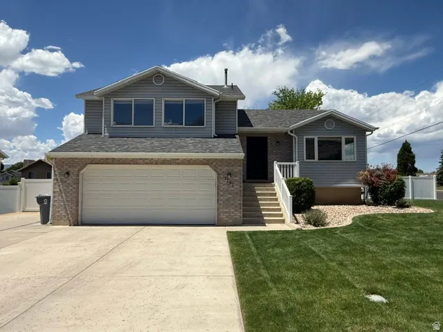 Two-story home featuring a combination of brick and siding exterior, an attached two-car garage, and a concrete driveway
