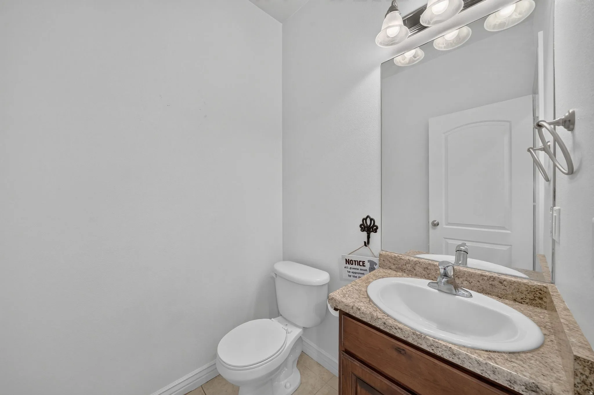 Bathroom vanity with a granite-style countertop, undermount sink, and chrome faucet