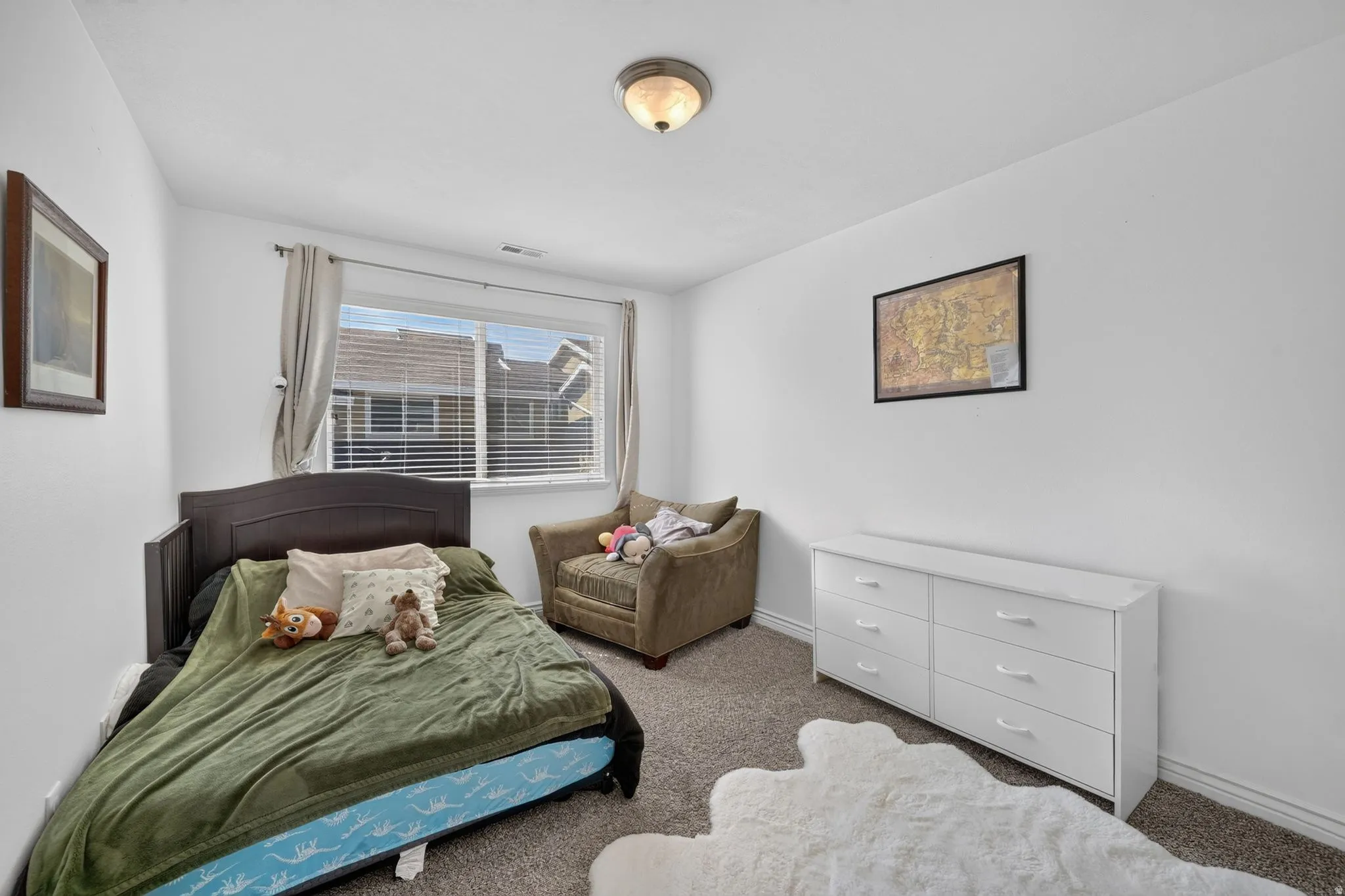 Bright room featuring a window with blinds, neutral wall paint, and carpet flooring