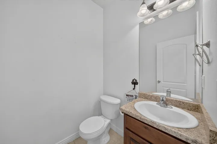 Bathroom vanity with a granite-style countertop, undermount sink, and chrome faucet