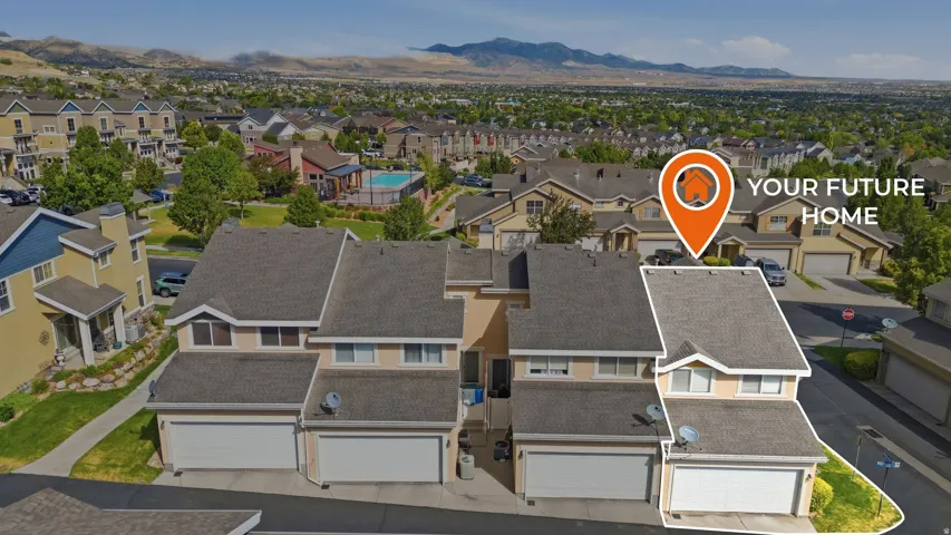 Two-story townhome with an attached garage and light stucco exterior