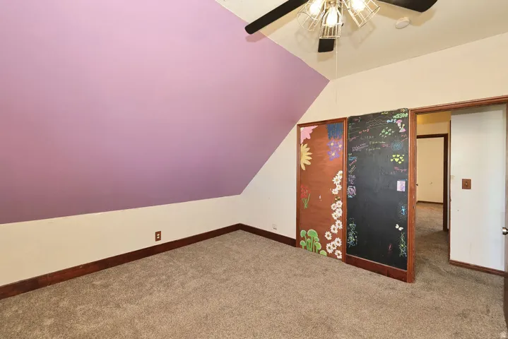 Bedroom featuring sloped ceilings, two-tone wall paint, and carpet flooring