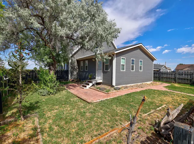 Grey siding exterior with white trim windows and a white front door