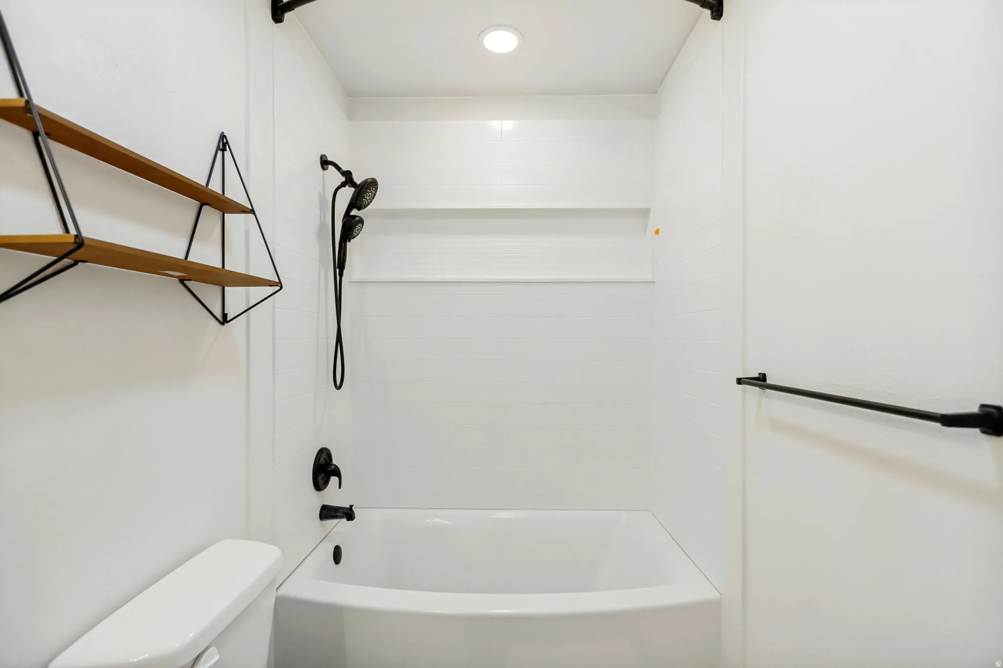 White tub and shower combination with matte black fixtures