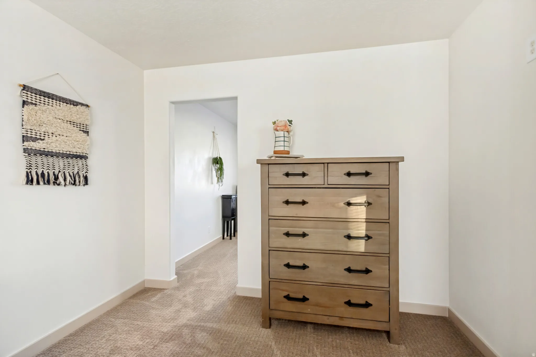 Plush neutral carpeting extends through the entryway, complemented by bright white walls and baseboards