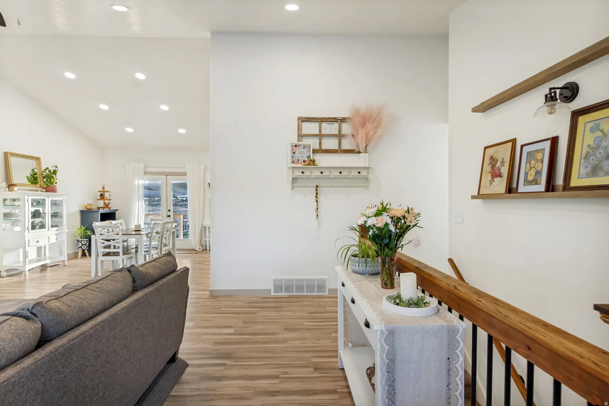 Open-concept living area with wood-finish flooring, recessed lighting, and white walls