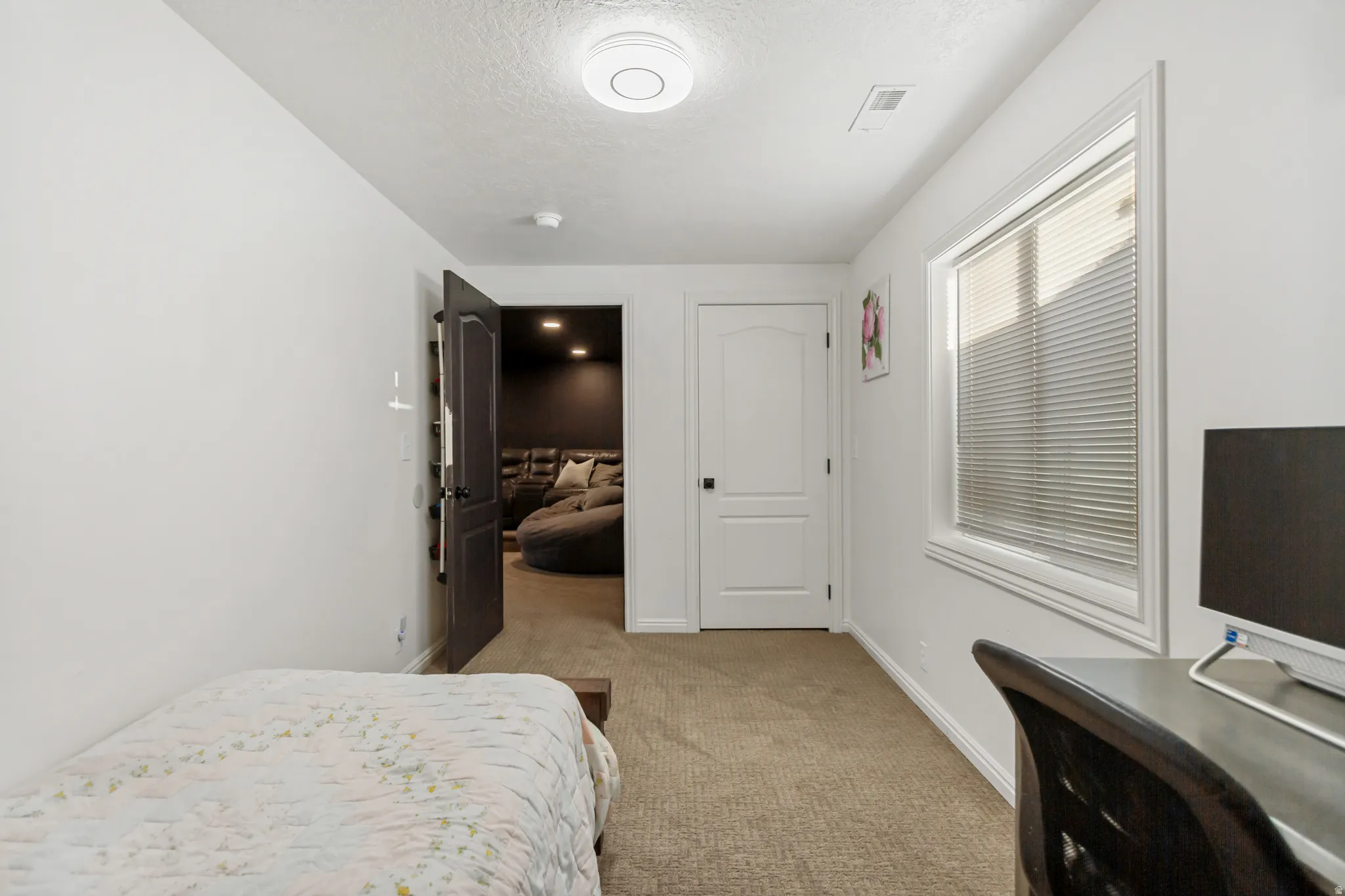 Carpeted interior space with a window featuring horizontal blinds