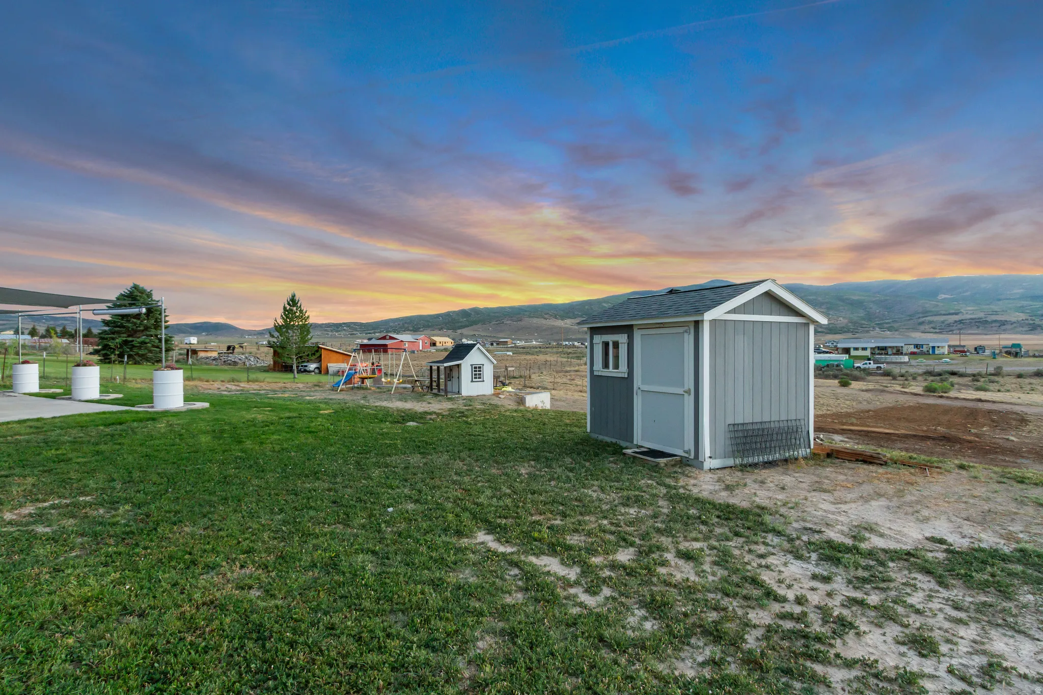 Gray storage shed with white trim and a single window