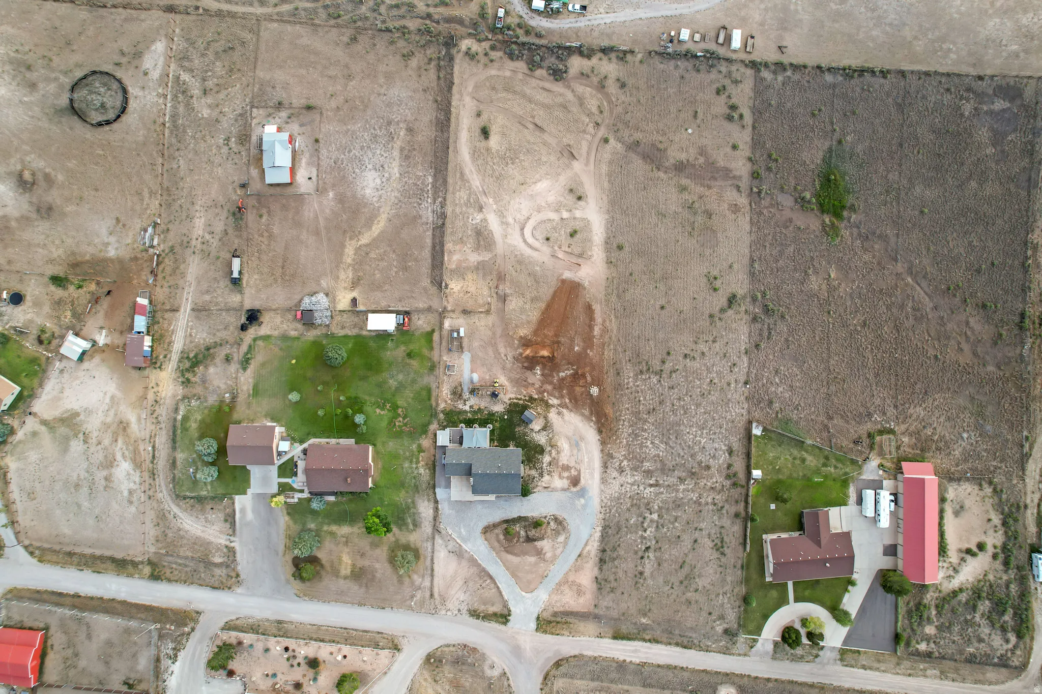 Aerial perspective showcasing multiple residential properties and surrounding undeveloped land