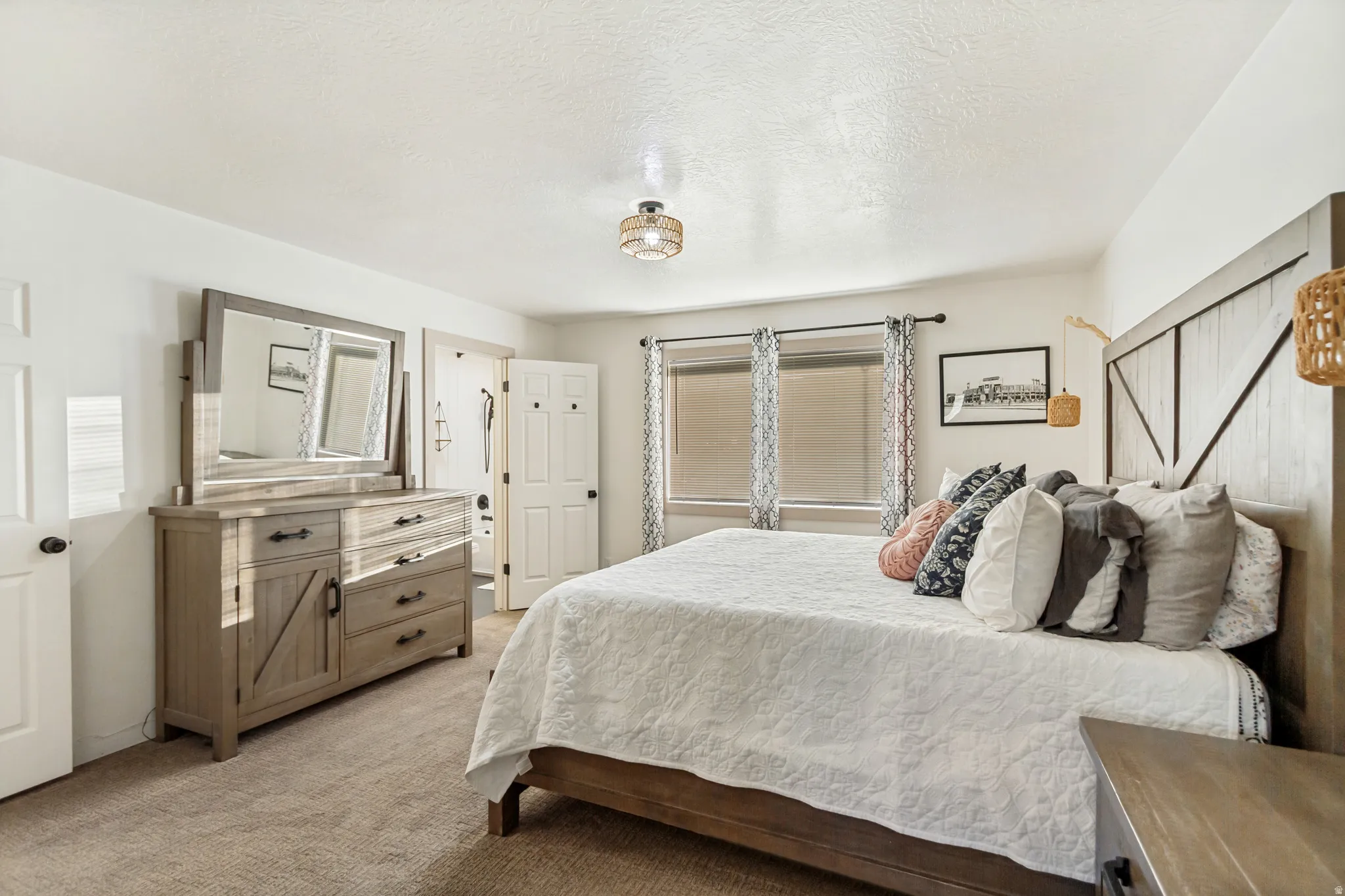Carpeted bedroom with white walls, two windows, and a ceiling-mounted light fixture