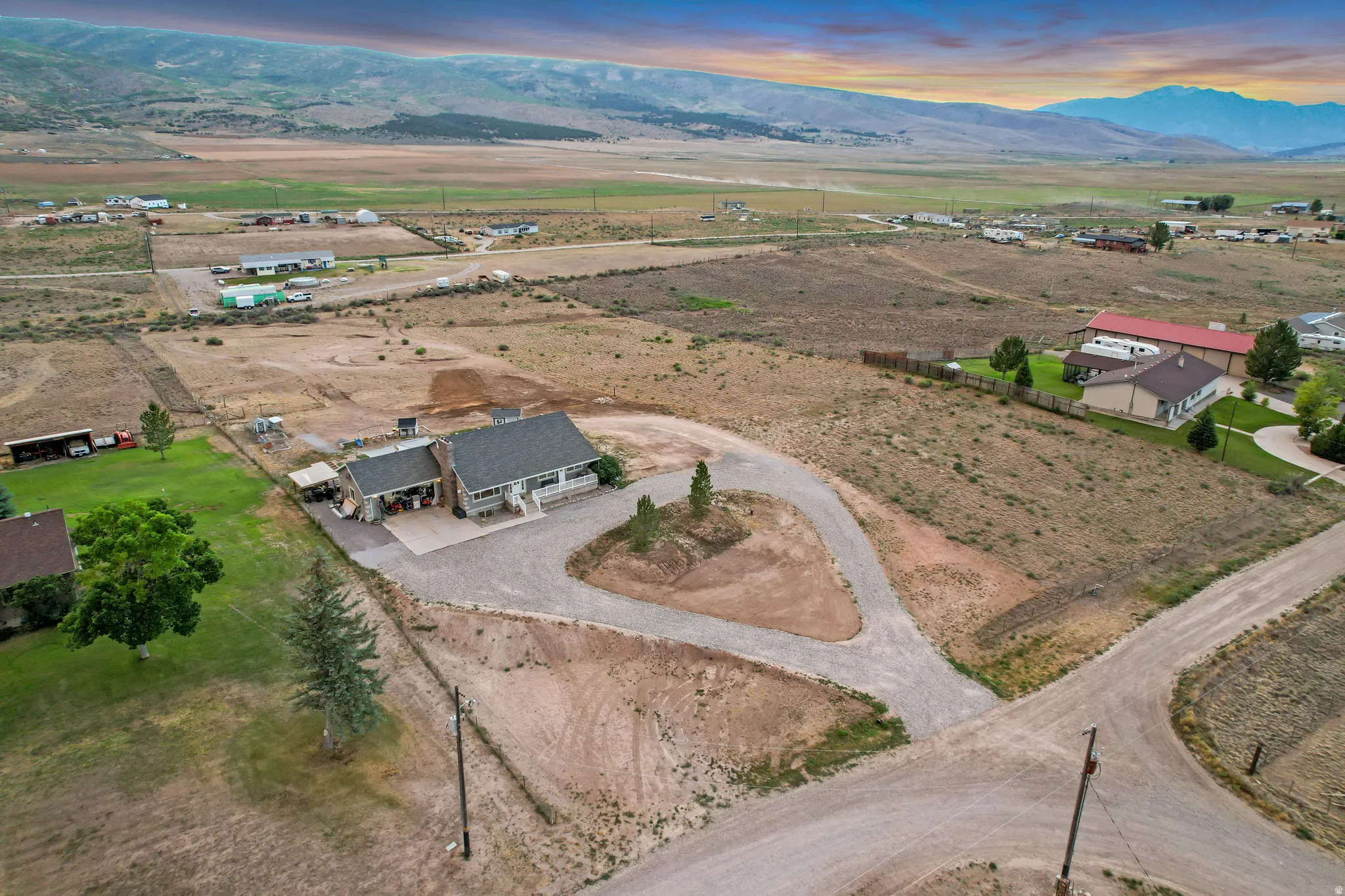 Single-story residence on an expansive lot featuring a gravel drive, covered front porch, and a pitched roof