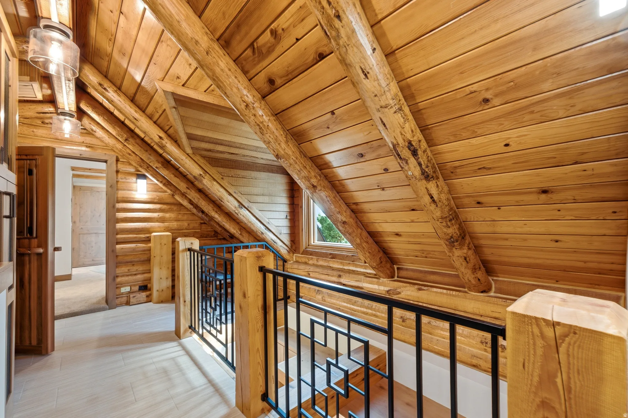 Warm wood-paneled ceilings with exposed timber beams, robust log walls, and light wood-finish flooring