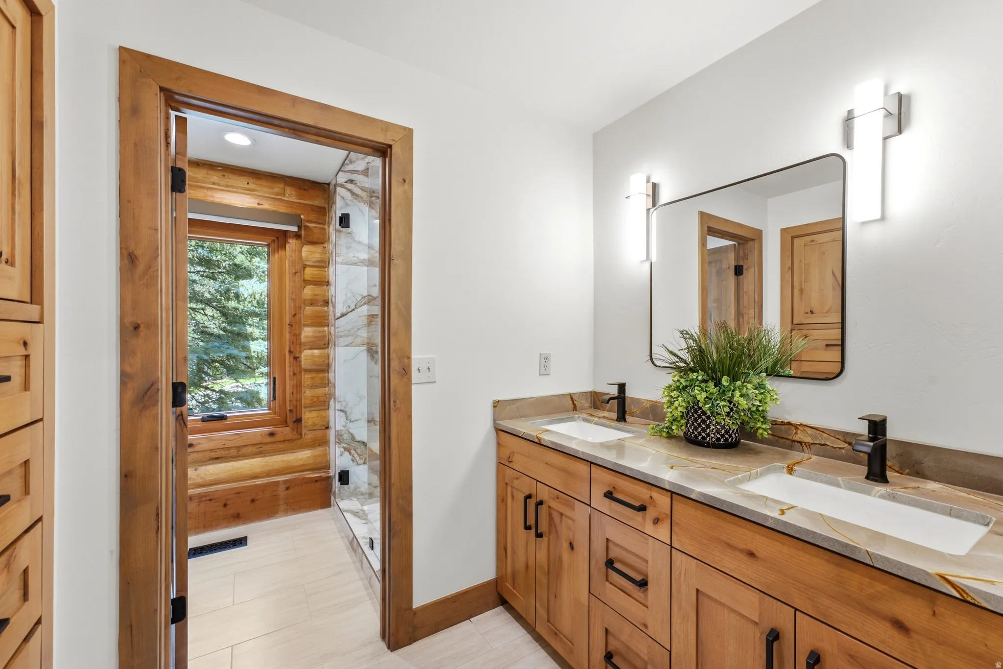 Dual vanity with custom wood cabinetry, stone countertops, and rectangular sinks