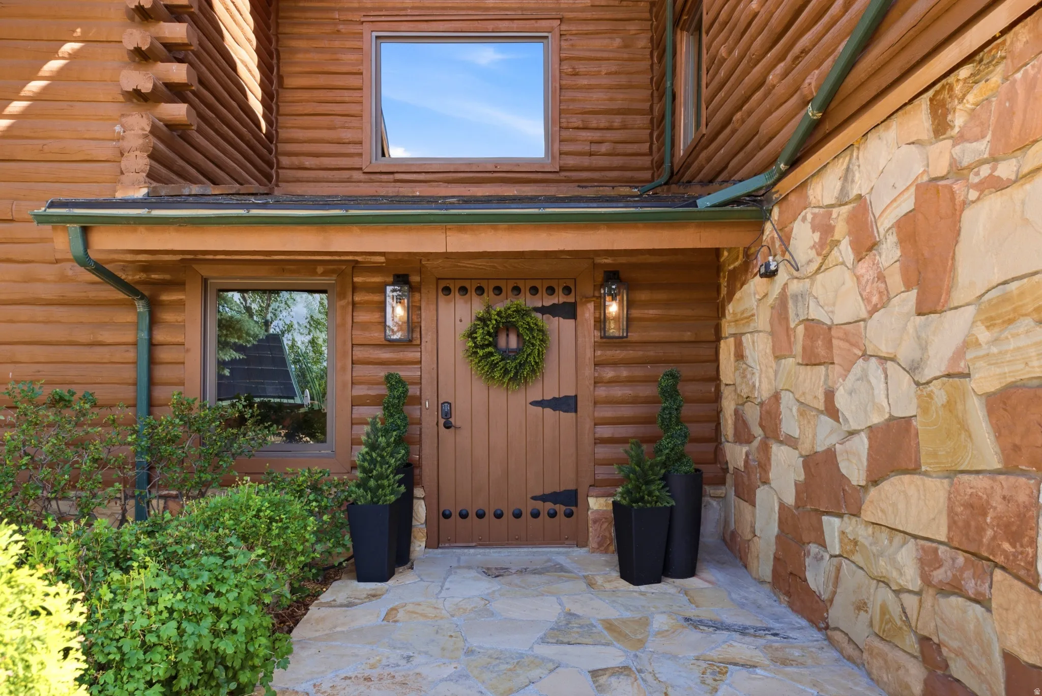 Stone and log siding exterior featuring a natural stone pathway