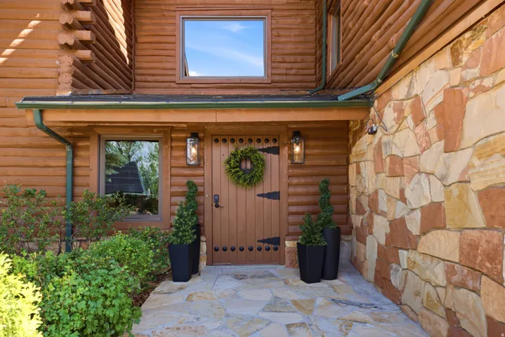 Stone and log siding exterior featuring a natural stone pathway
