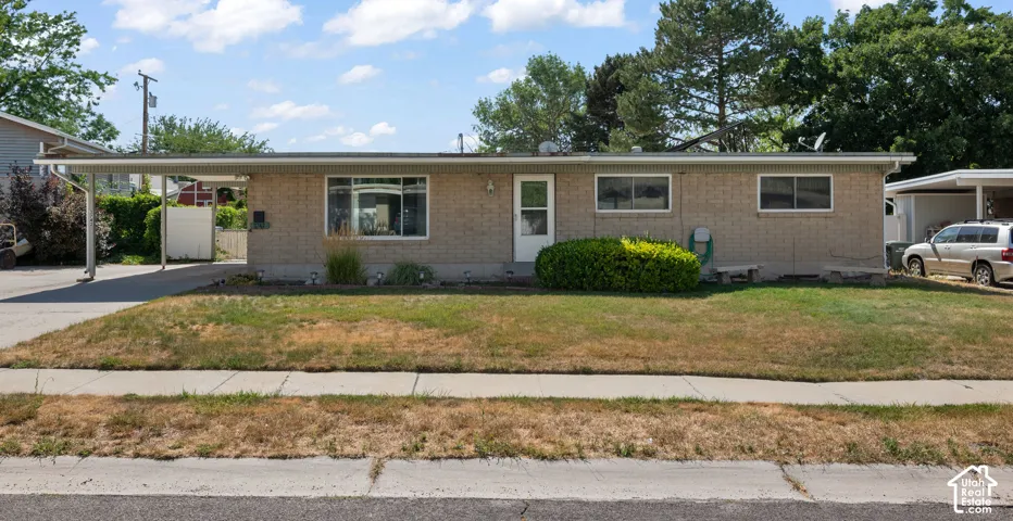 Single-story brick exterior featuring an attached carport and a concrete driveway