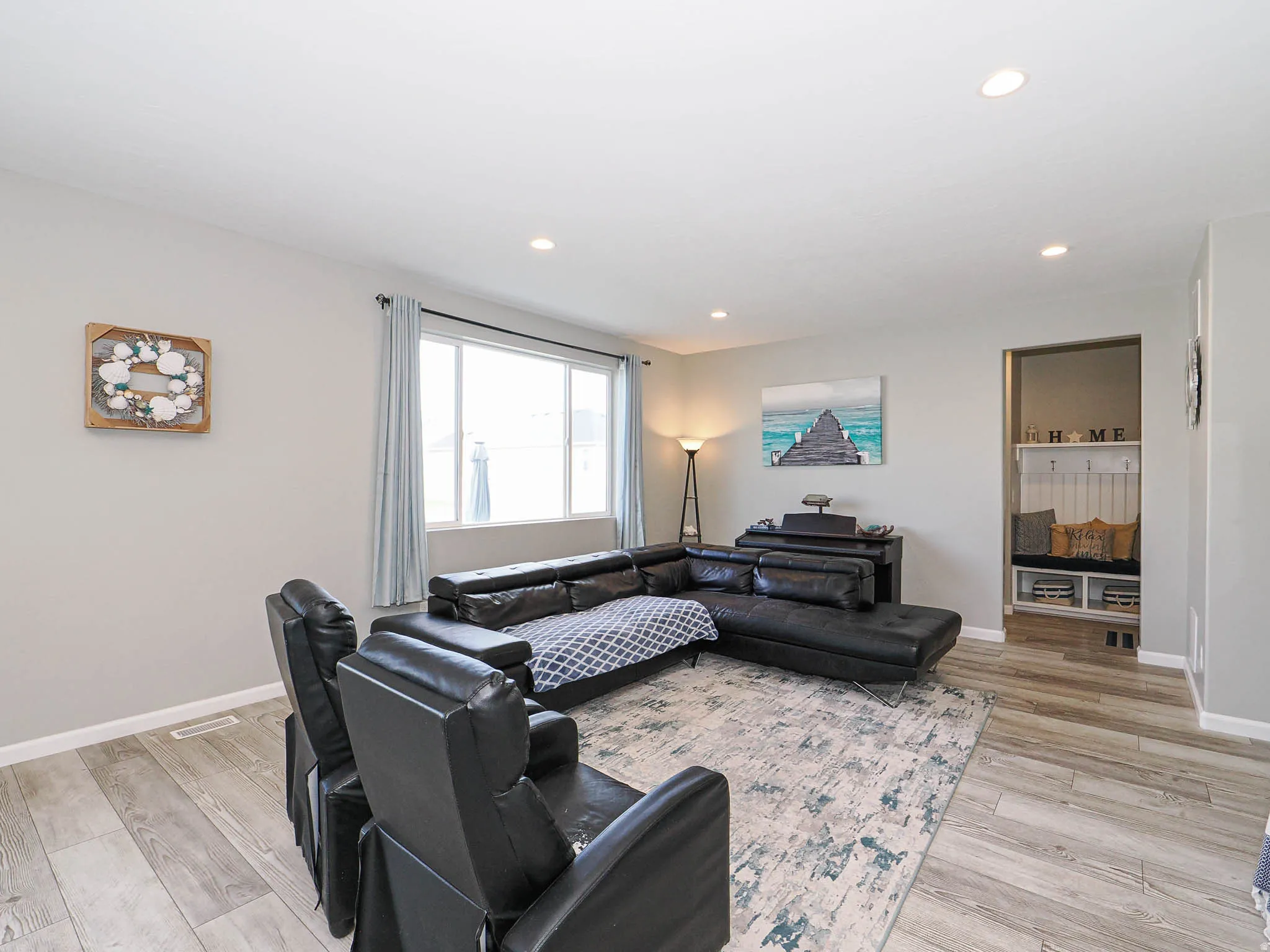 Living area featuring light wood-finish flooring and recessed lighting