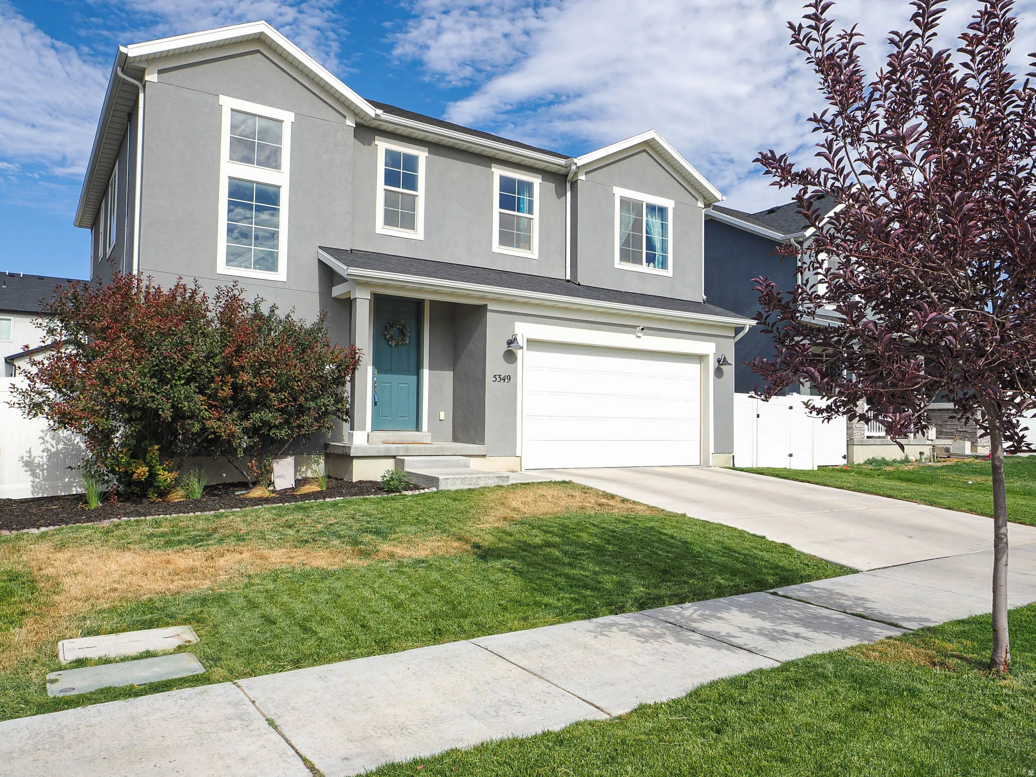 Contemporary two-story residence featuring a gray stucco exterior with white trim