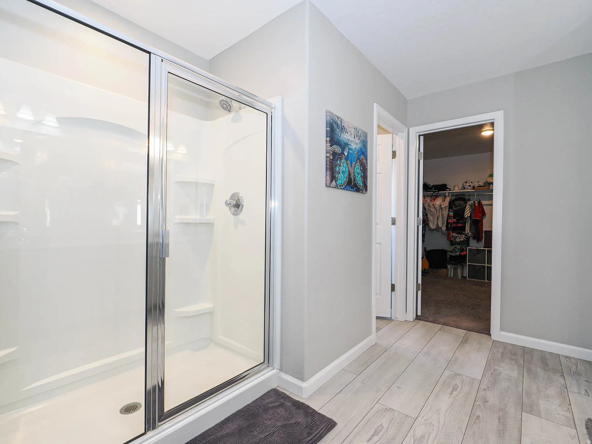 Shower enclosure with clear glass doors and chrome hardware