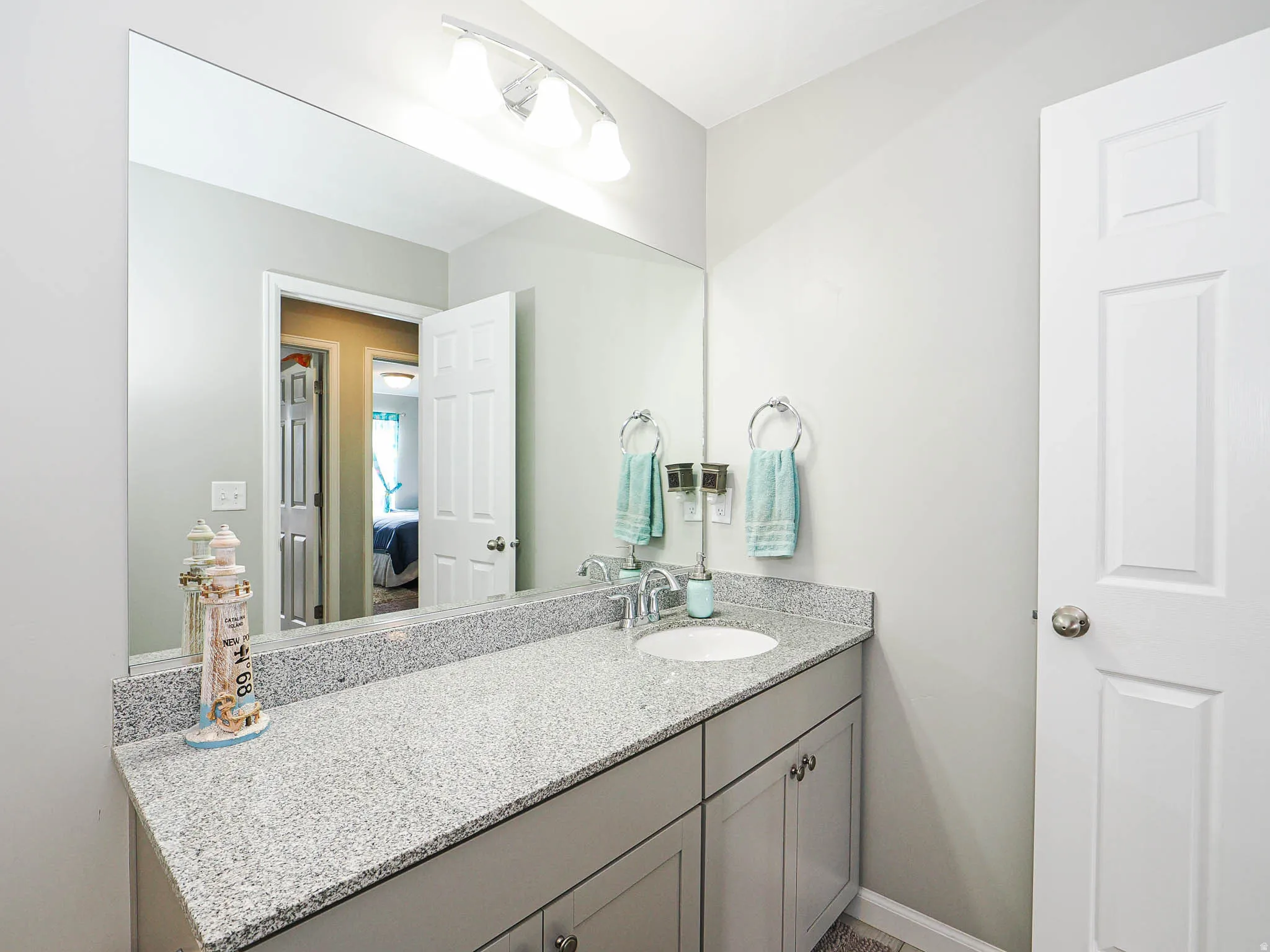 Bathroom vanity featuring a speckled countertop, integrated sink, and brushed nickel faucet